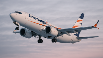 Lietadlo Boeing 737 spoločnosti Smartwings stúpa po štarte na oblohe počas zimného súmraku, záber z nízkeho uhla, na trupe veľký čitateľný nápis Smartwings.