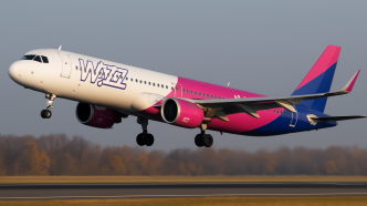 Airbus A321neo Wizz Air vo fialovo-ružovej livreji tesne po vzlete z dráhy, záber z nízkeho uhla za jasného jesenného rána