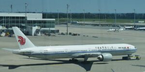 Lietadlo Boeing 777-300ER spoločnosti Air China vytláčané od terminálu na letisku Mníchov, v pozadí letiskové budovy