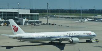 Lietadlo Boeing 777-300ER spoločnosti Air China vytláčané od terminálu na letisku Mníchov, v pozadí letiskové budovy