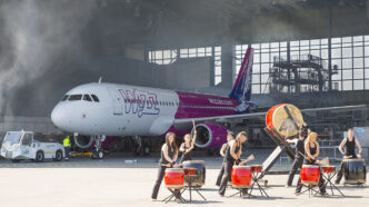 Lietadlo Wizz Air s pristavenými schodmi a pozemným personálom