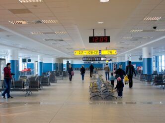Čakacia zóna pri odletovej bráne s radmi sedadiel a cestujúcimi