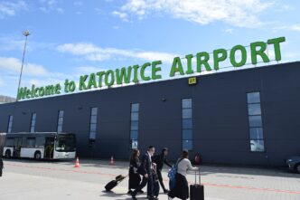 Cestujúci s batožinou pred terminálom letiska Katowice