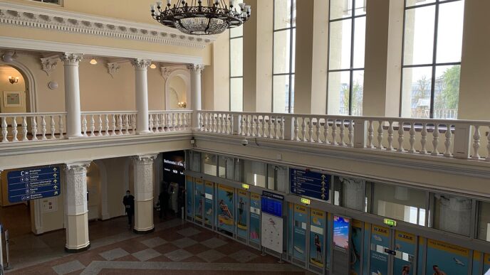 Odbavovacia hala letiska Vilnius s prepážkami a informačnými tabuľami, pohľad z poschodia