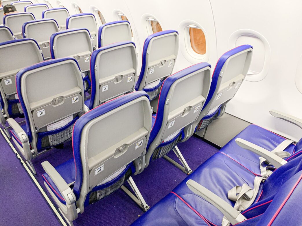 Kabína lietadla Wizz Air Airbus A321neo s radmi fialovo-modrých sedadiel