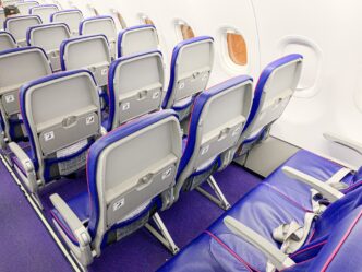 Kabína lietadla Wizz Air Airbus A321neo s radmi fialovo-modrých sedadiel